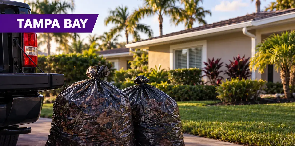 Bagged gutter debris ready to be hauled away beside a service truck at a Tampa Bay home